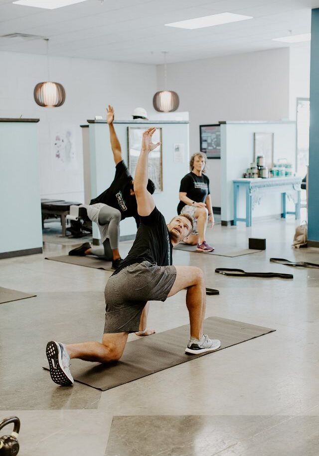 Ryne Malone leading a class in yoga poses